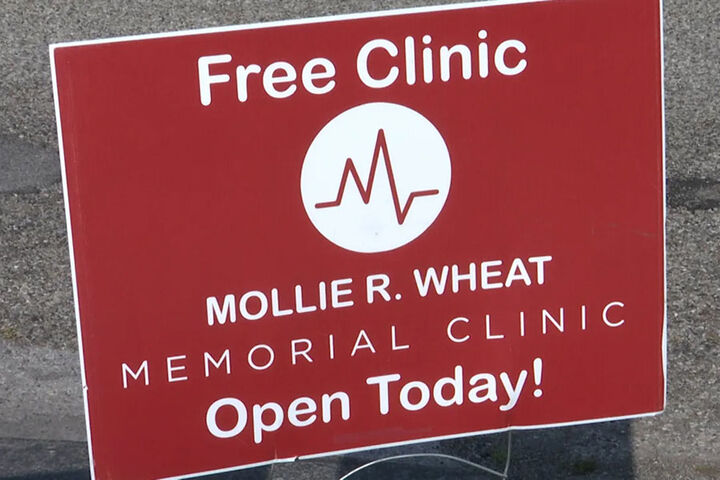 A red yard sign for the Mollie R. Wheat Memorial Clinic.